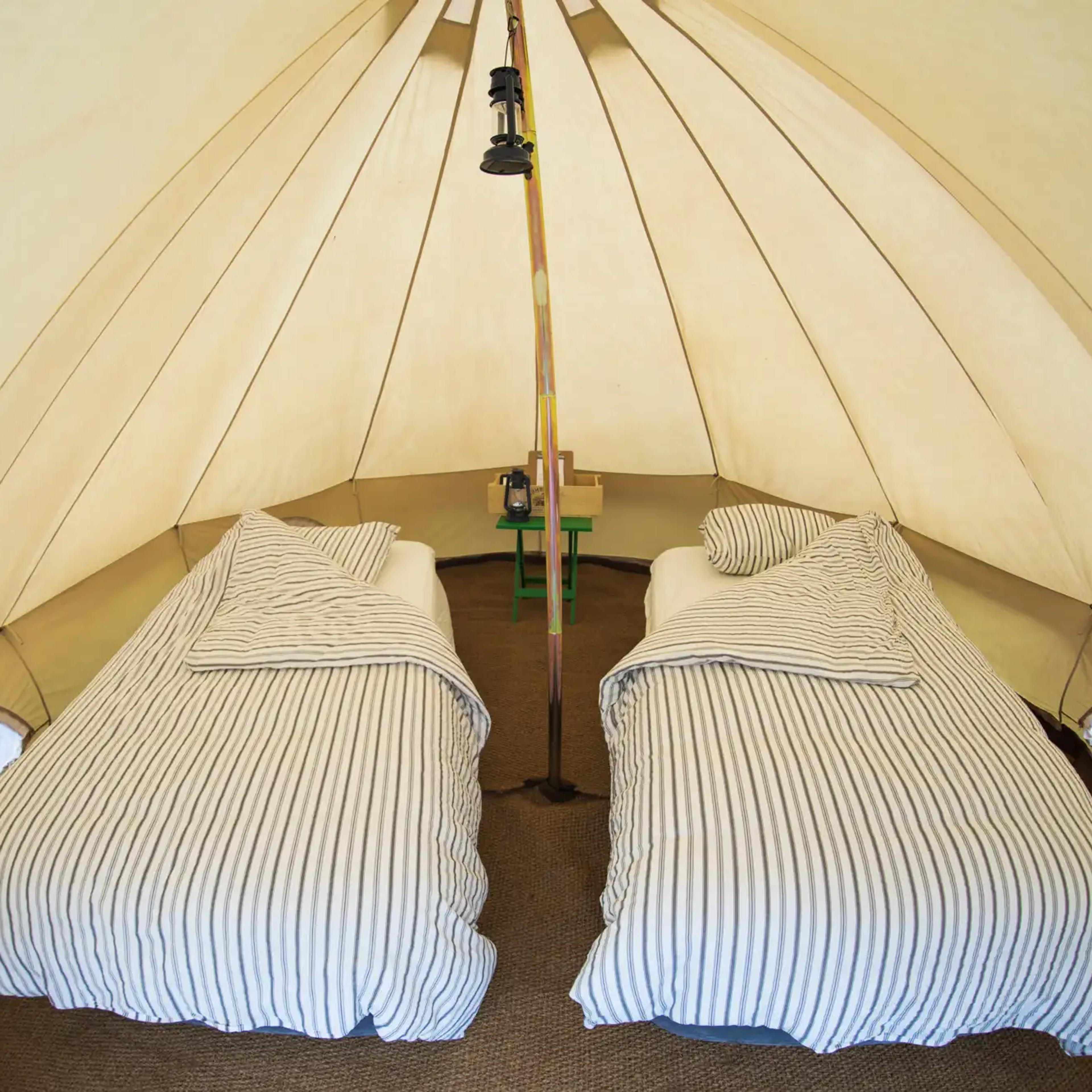 Cozy beds inside a white canvas bell tent