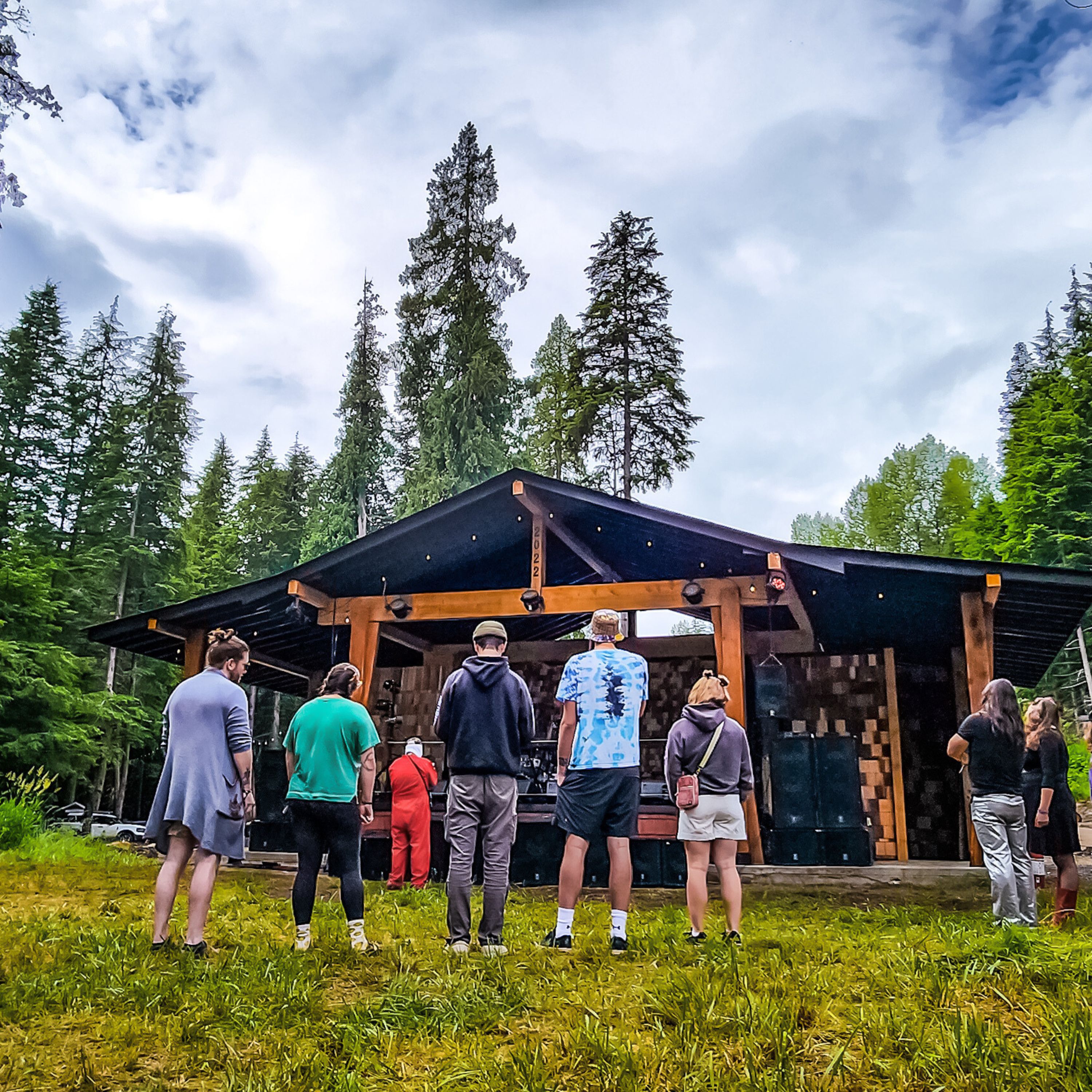 Festival attendees gathered on grass in front of AgeHa stage.