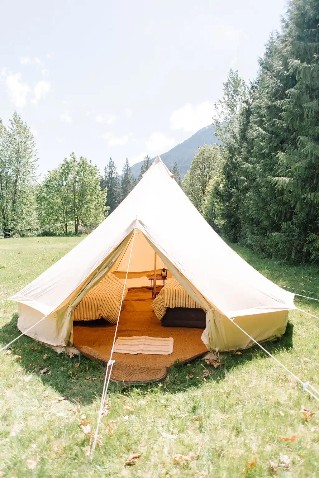 White canvas bell tent set up in a field