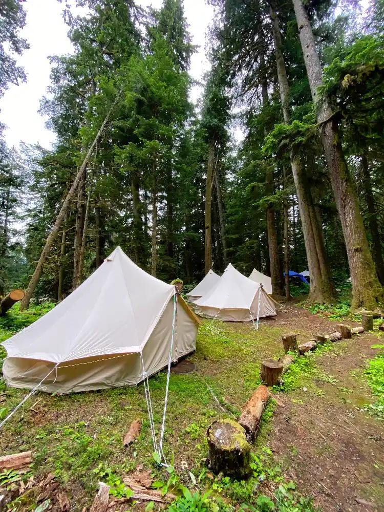 Four white canvas bell tents set up at ValhallaFest