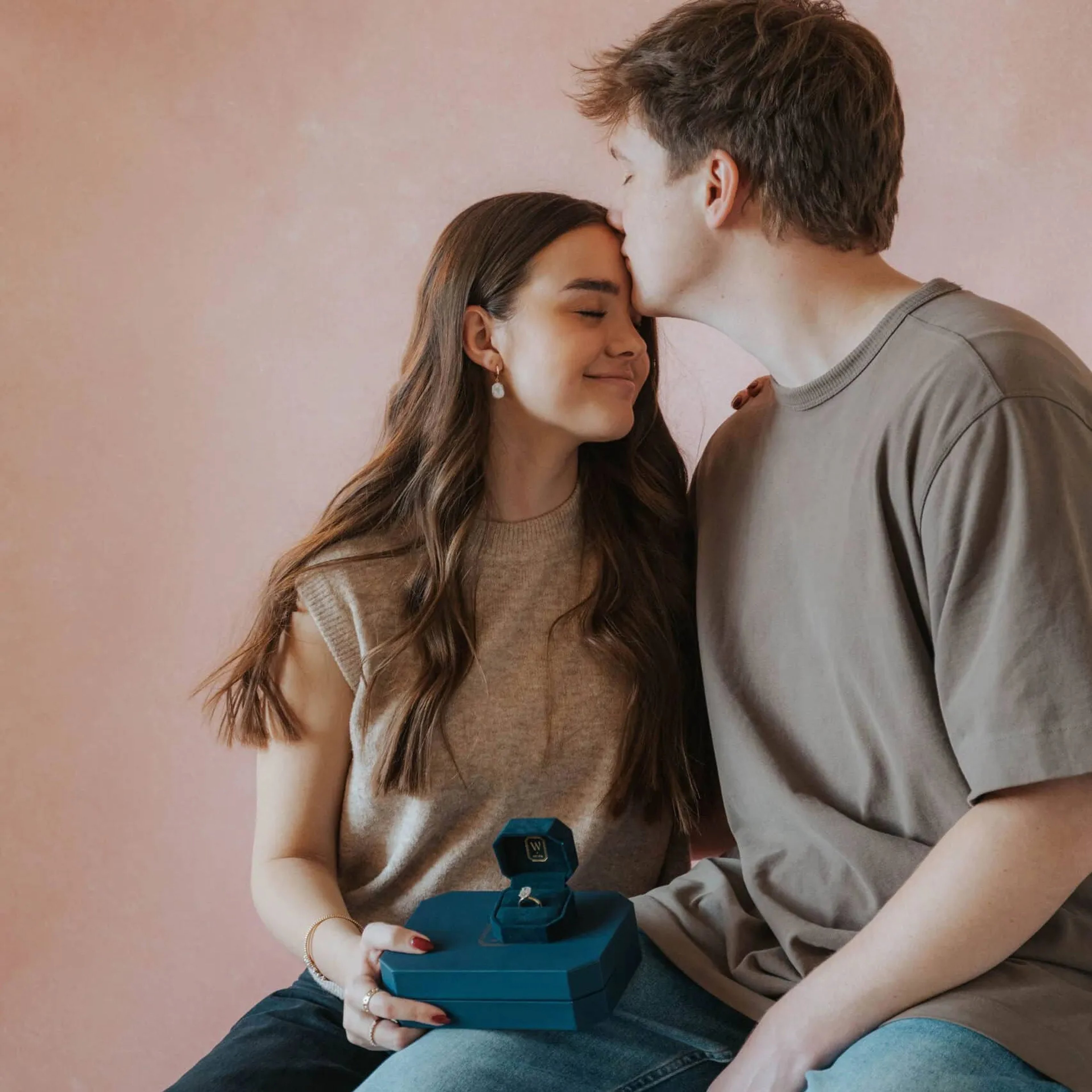 Close-up of a boy kissing a girl on the forehead.