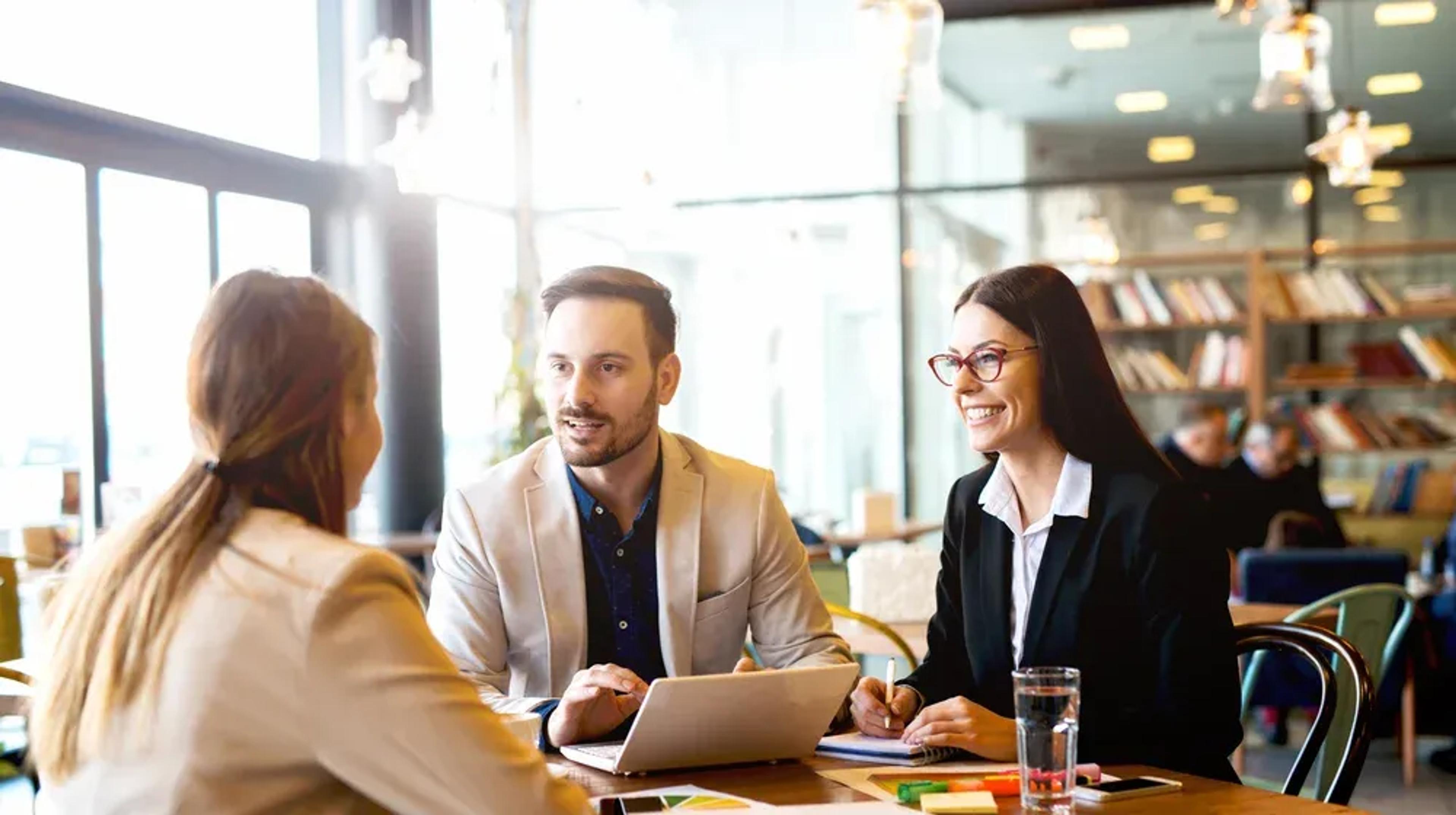 Two women and a man having a discussion. 