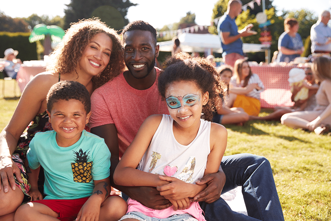 a family posing for a picture while sitting on the grass