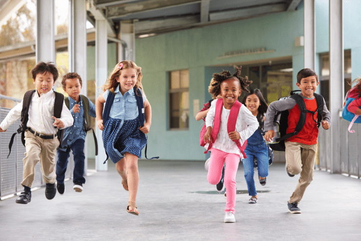 Kids playing in front of a school