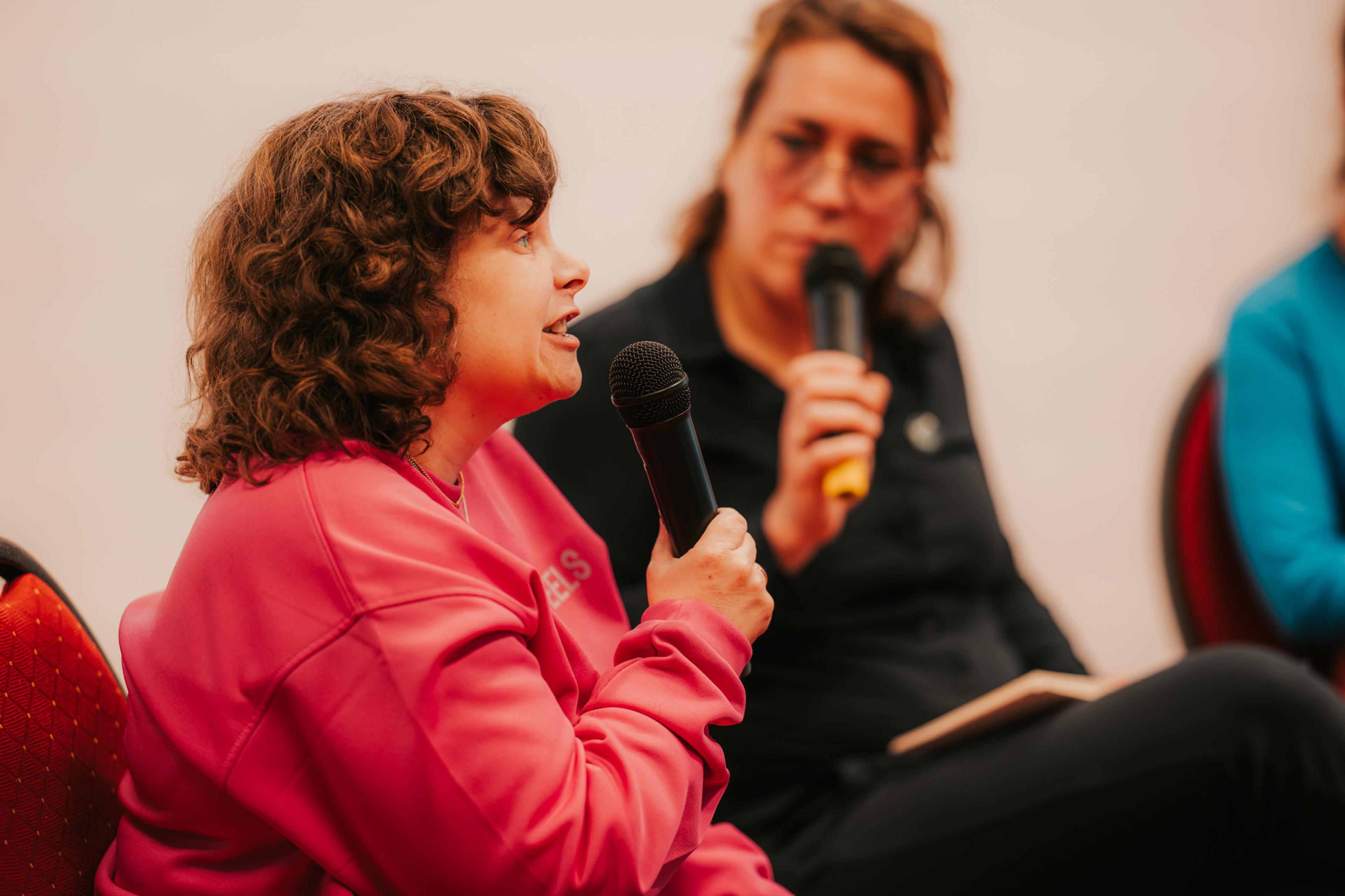 Woman in wheelchair talks into microphone
