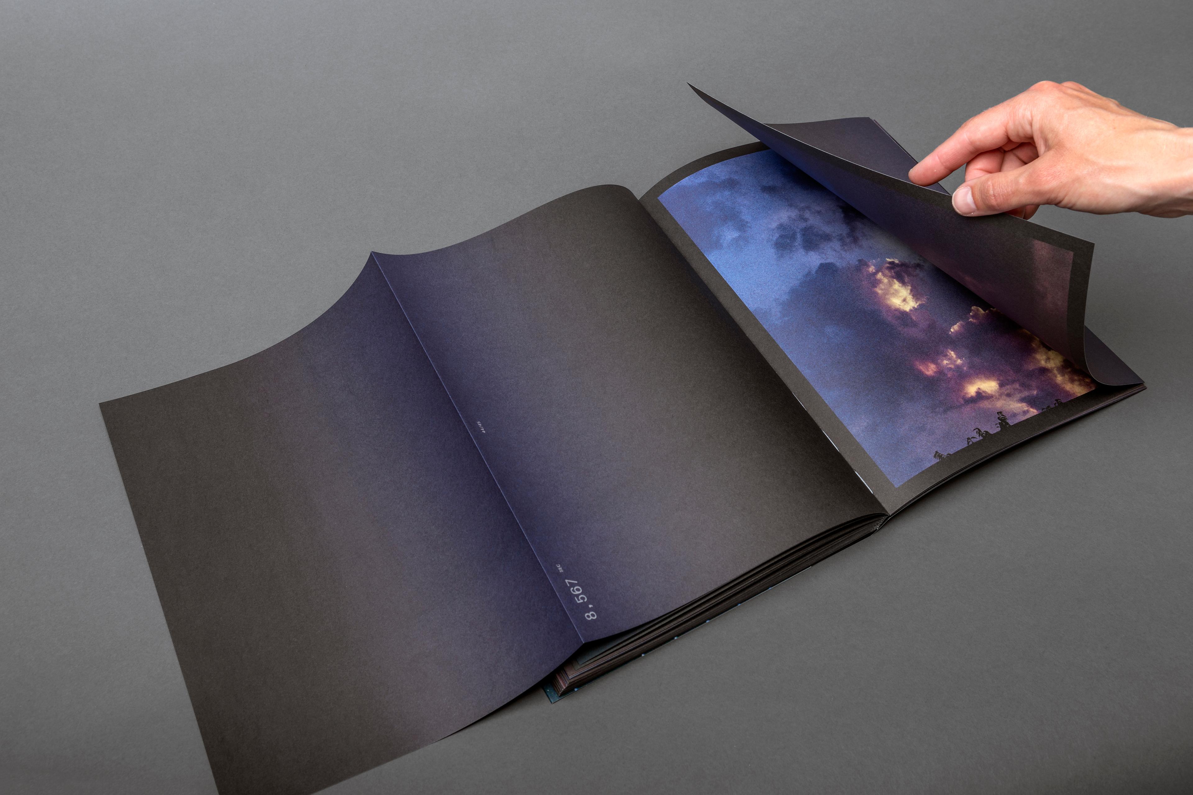 Photo of the SYNC photo book with a hand turning the page