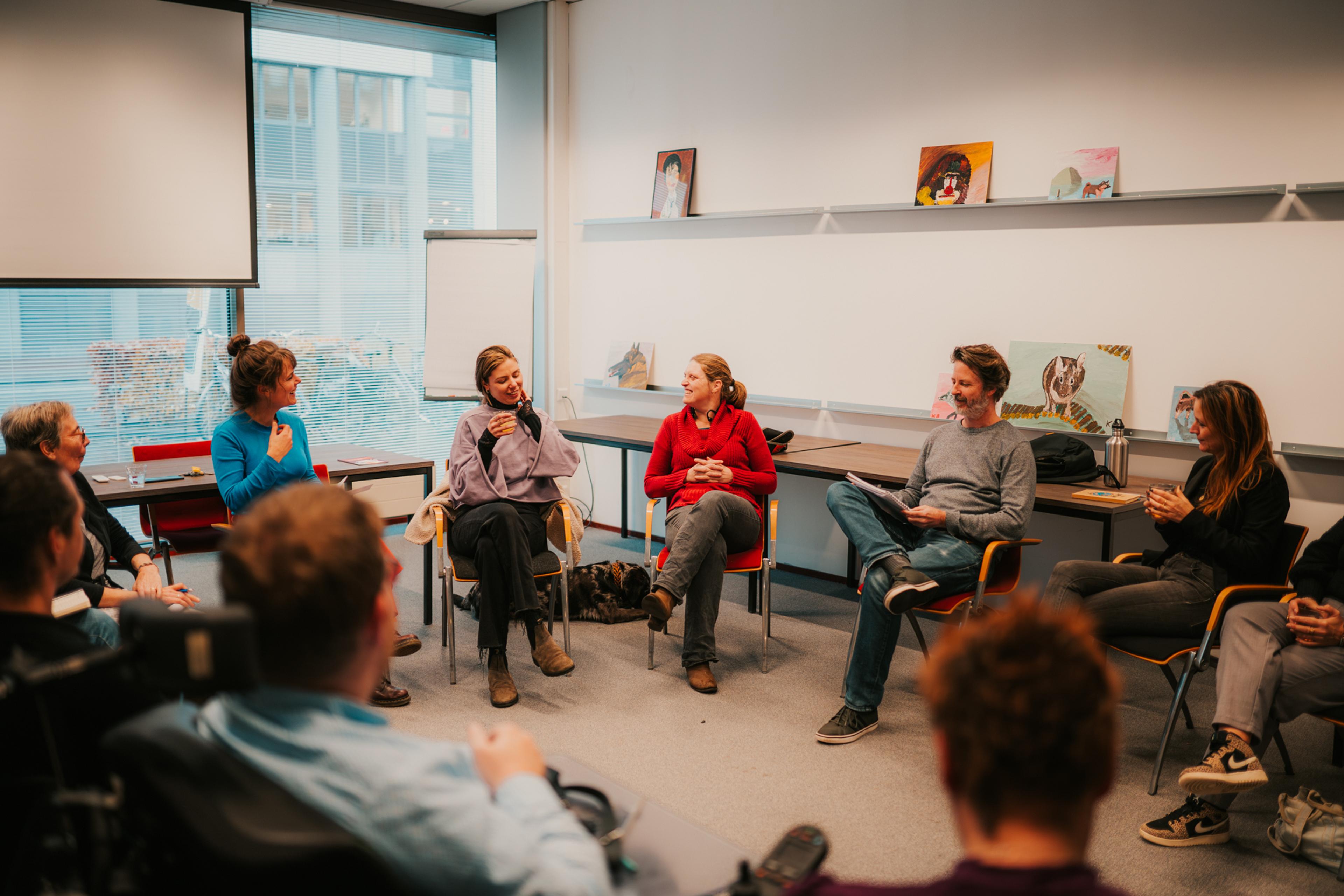 Group sits in circle during workshop