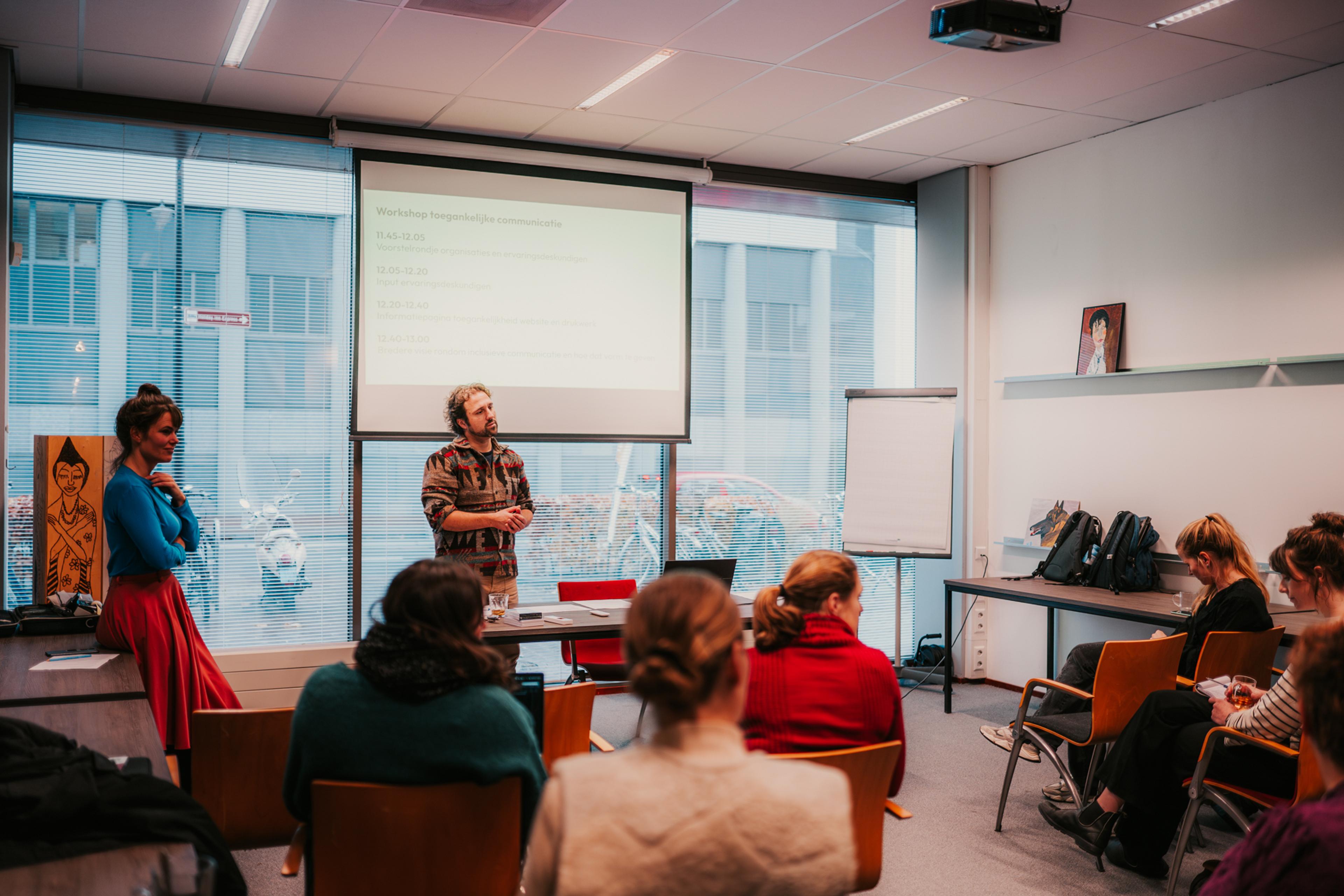 Man en vrouw staan voor groep te vertellen