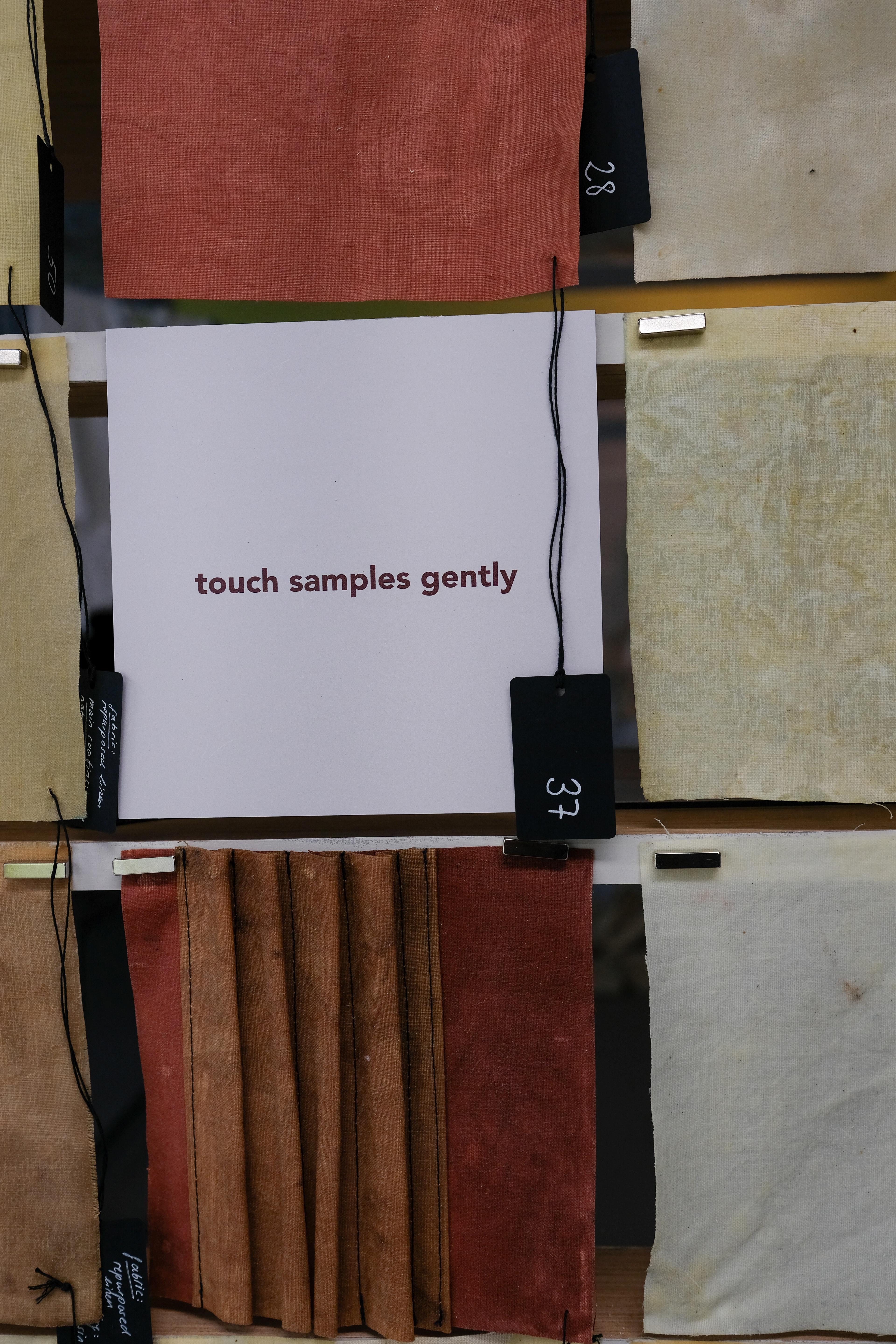 Een close-up van de samples, waarbij een wit kaartje tussen de samples aangeeft dat je de samples voorzichtig aan moet raken 'touch samples gently'
