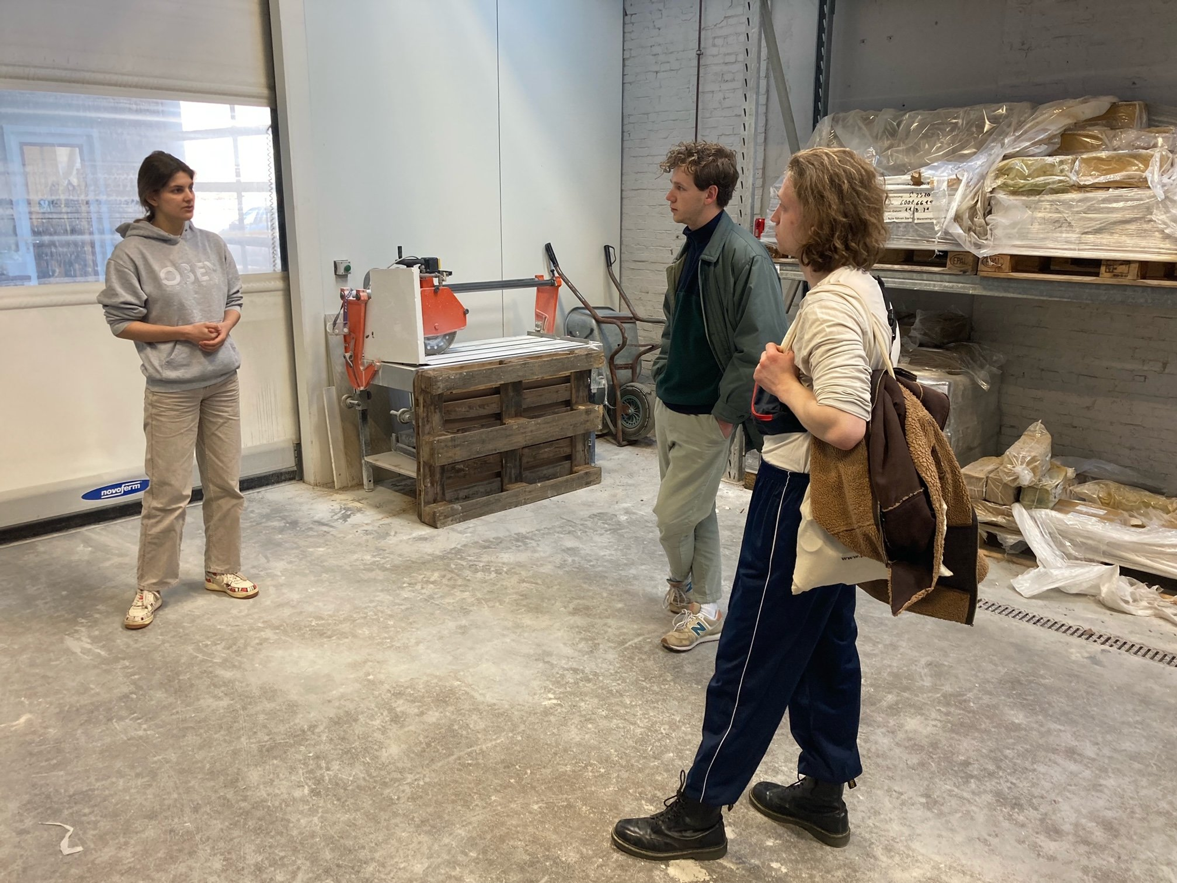 Foto van drie mensen in een werkplaats