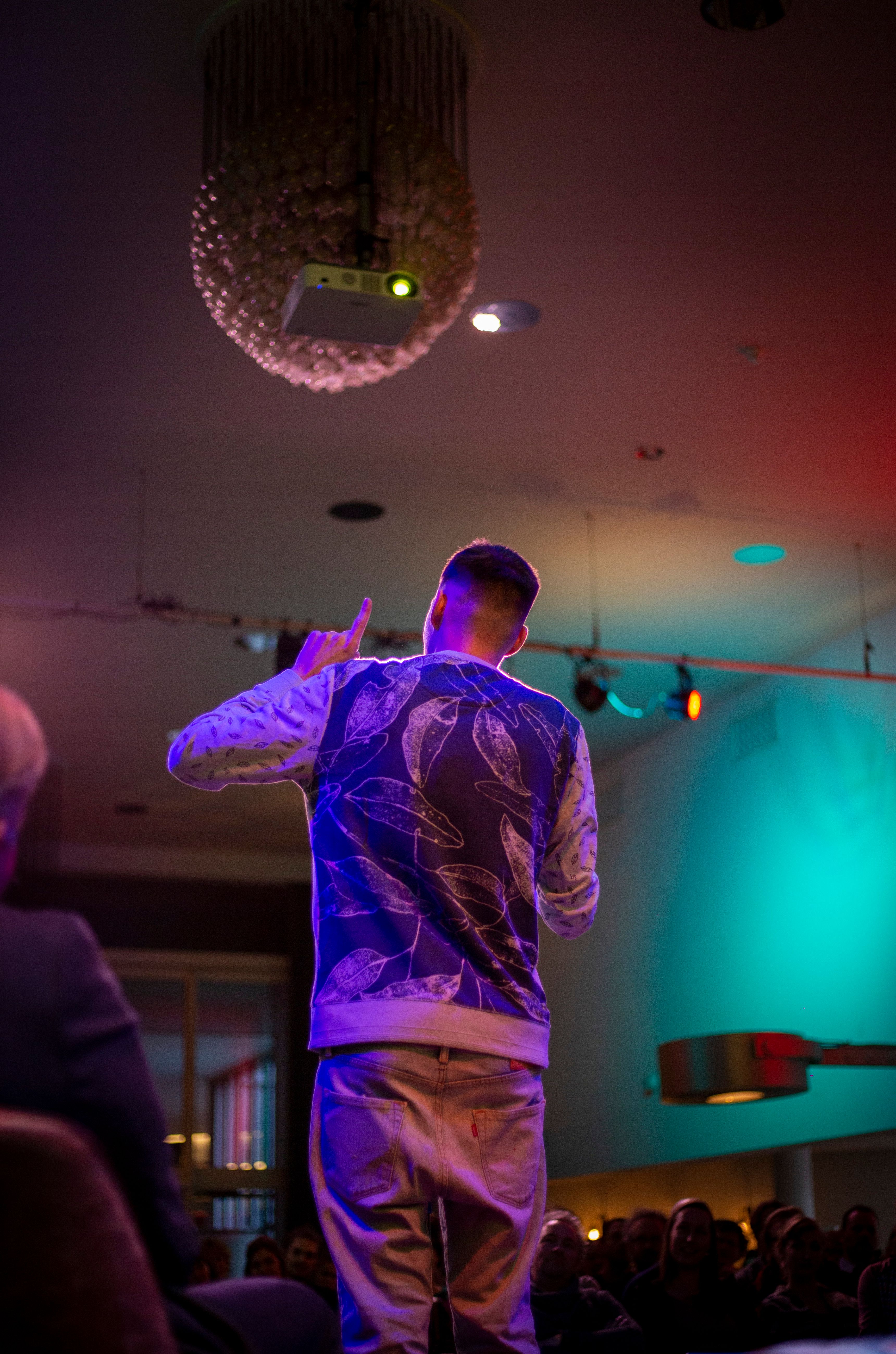 Foto van de rug van Cees de Beer, sprekend door een microfoon