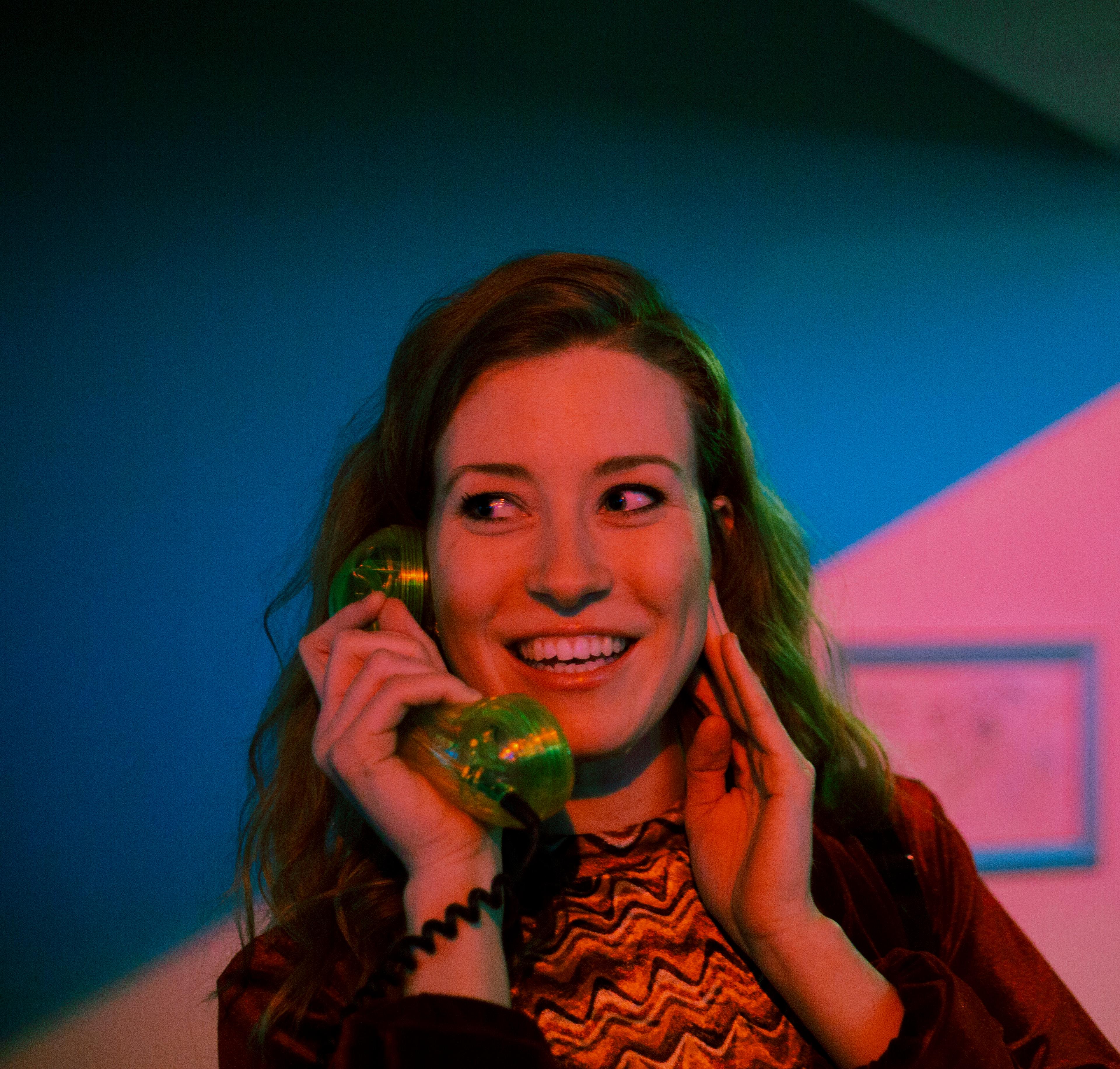 Foto van vrouw, luisterend naar een ouderwetse telefoon