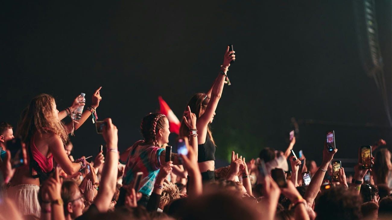 Young people in an audience standing and cheering.