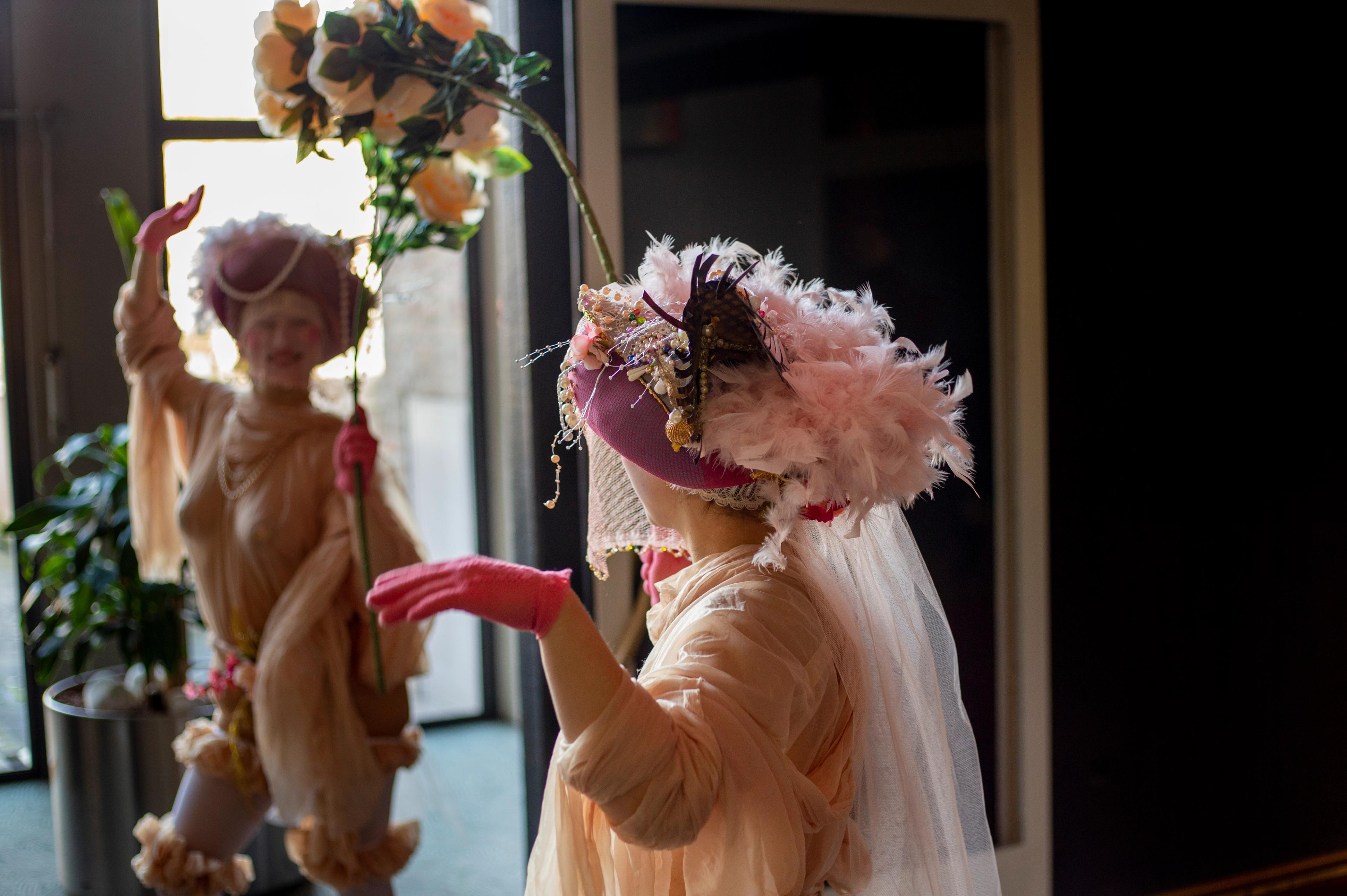 Foto van twee vrouwen in droomachtig kostuum en tussen hen een boog van bloemen