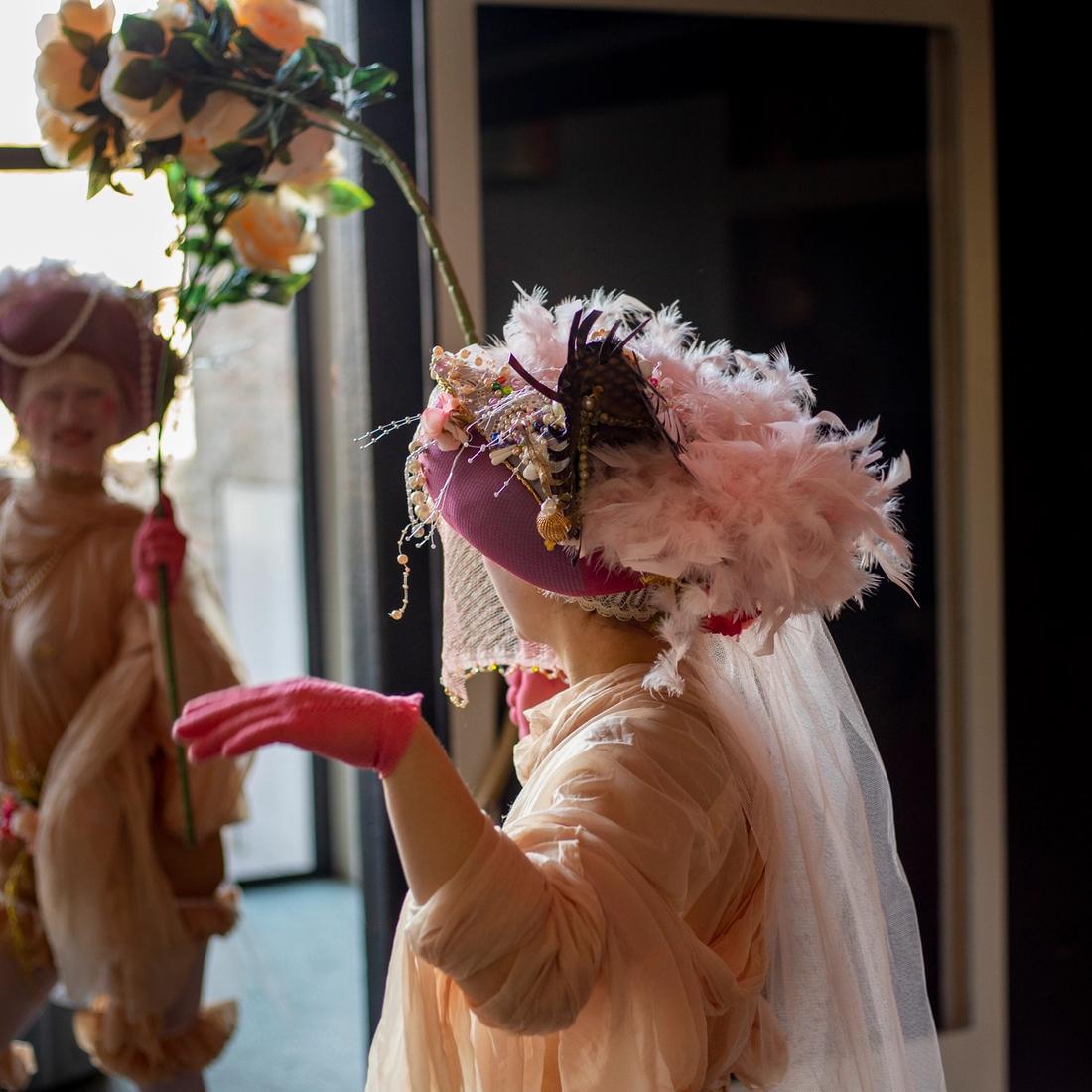 Twee vrouwen in dromerig kostuum met tussen hen in een bloemenboog
