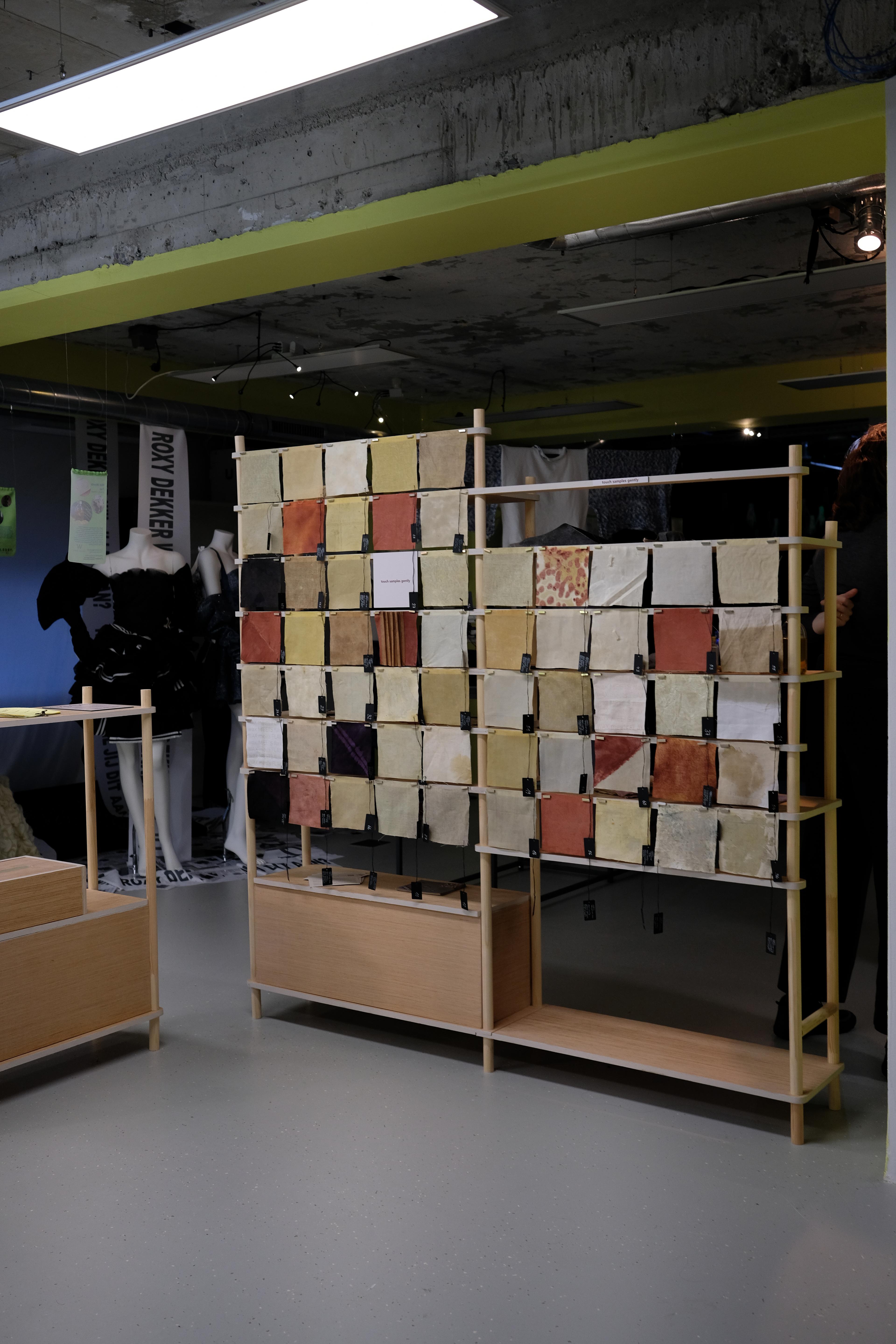 De materialen van het project tentoongesteld tijdens Dutch Design Week, de samples worden getoond hangend aan een houten stellage.
