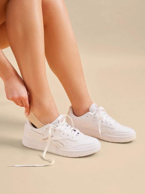 Sneaker on-model photography with natural gesture in soft light — GoPackshot