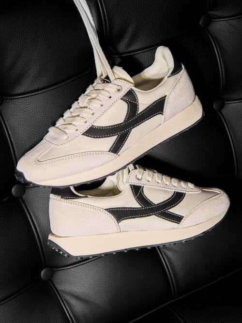 Sneaker pair creative photography on leather seat — footwear ecommerce GoPackshot