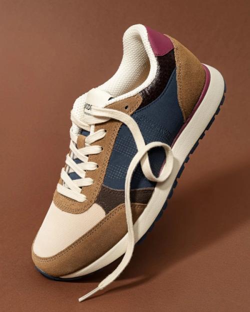 Sneaker single artistic angle packshot on warm background — GoPackshot