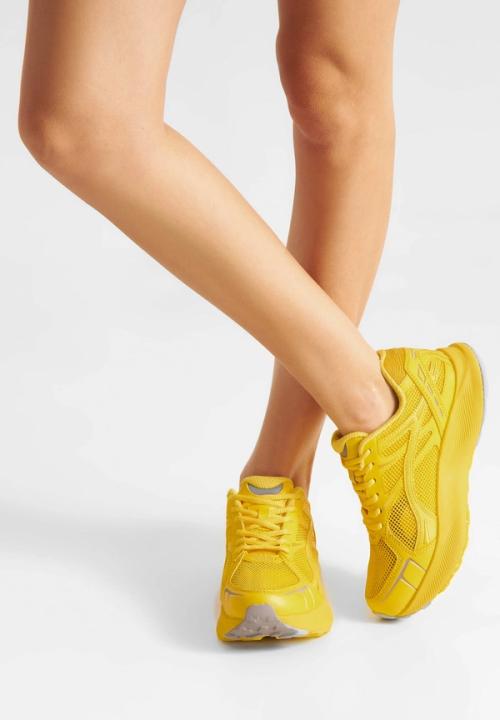 Sneaker on-model photography with crossed legs white background — GoPackshot