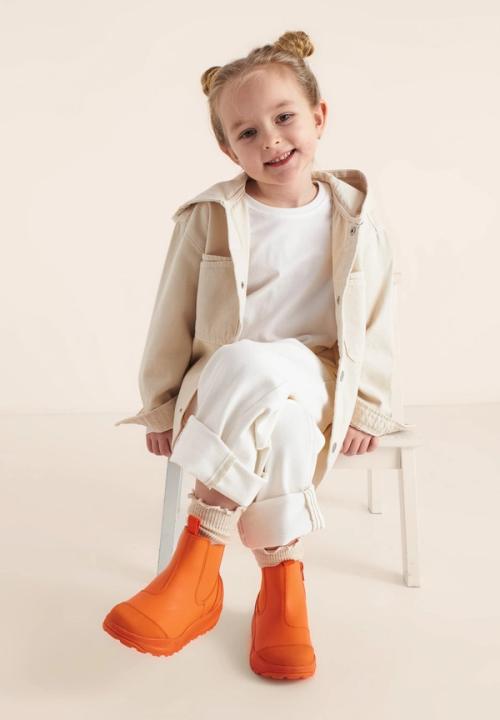 Kids rain boot on-model photography in warm studio setting — GoPackshot