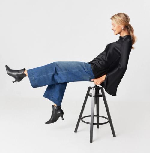 Ankle boot on-model photography in seated studio pose — GoPackshot studio