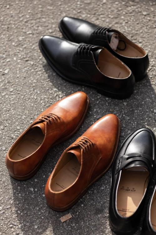 Dress shoe collection lifestyle photography on textured surface — GoPackshot