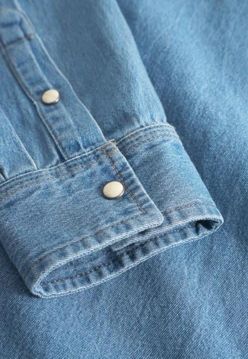 Denim shirt cuff snap button detail — macro GoPackshot