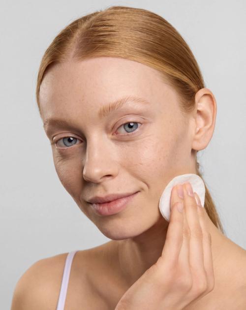 Facial toner pad on-model application photography — GoPackshot studio