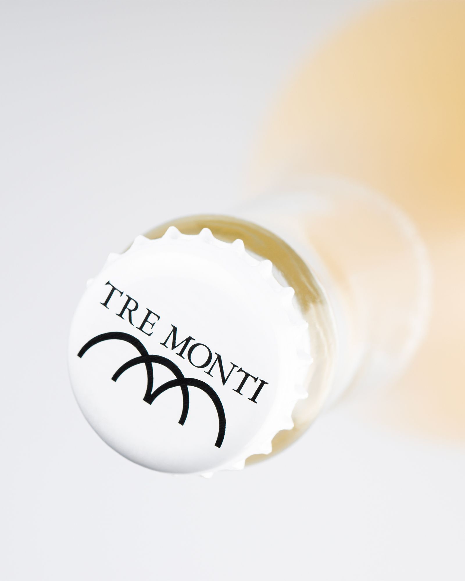 Detail of the white cork of a Tre Monti bottle with black logo on the background.