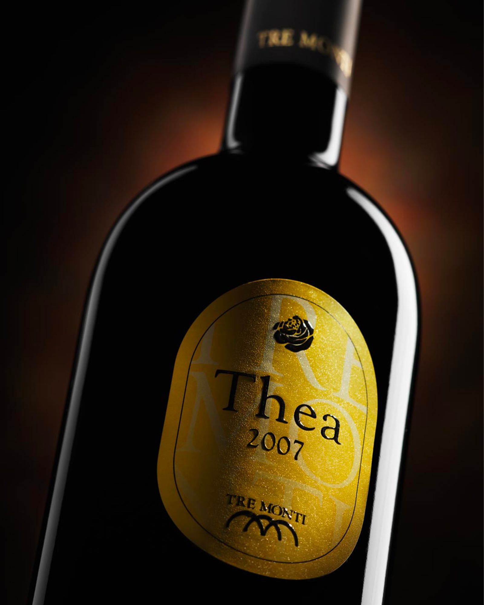 A bottle of Tre Monti Thea 2007 wine with a gold label on a dark background.