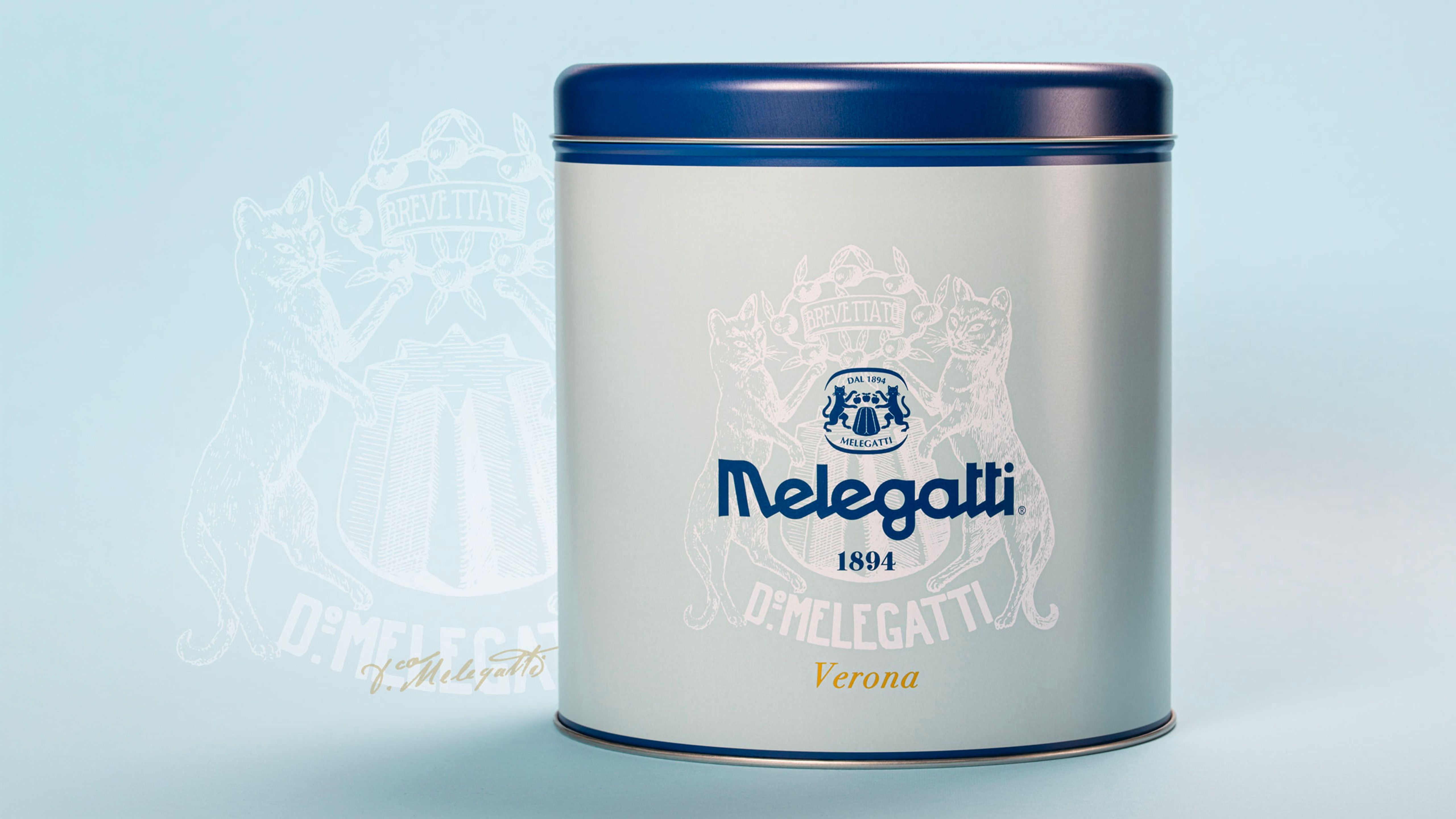 White Melegatti metal tin with blue lid, crest logo and 'Verona' lettering, on a light-blue background.