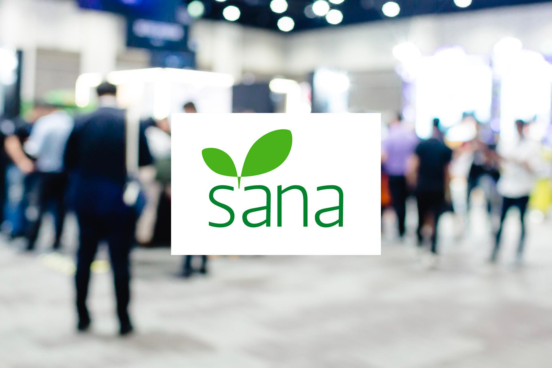 logo-sana-su-sfondo-sfocato-di-una-fiera-con-persone