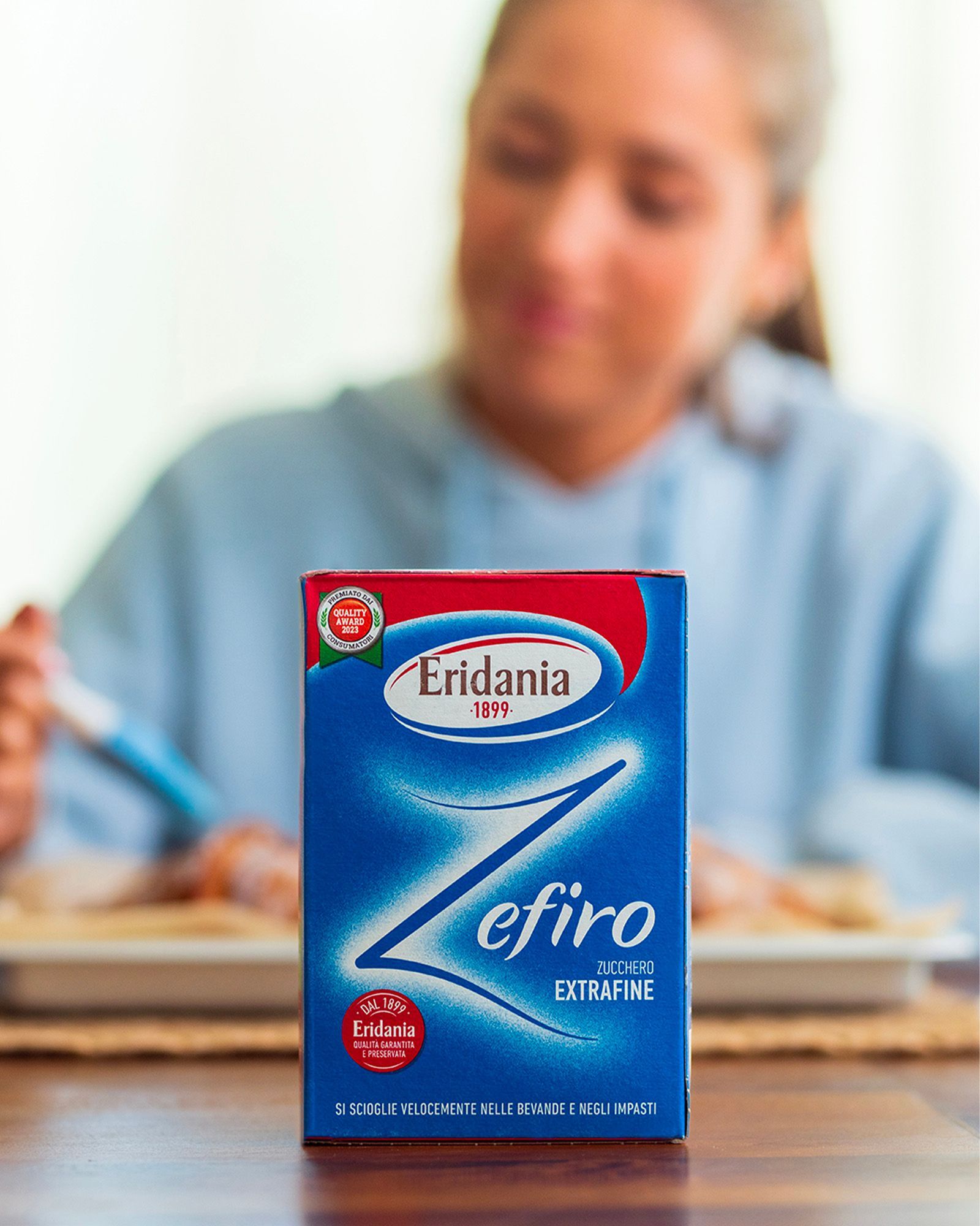 Pack of Eridania Zefiro extra-fine sugar in close-up, with a blurred person at the table in the background