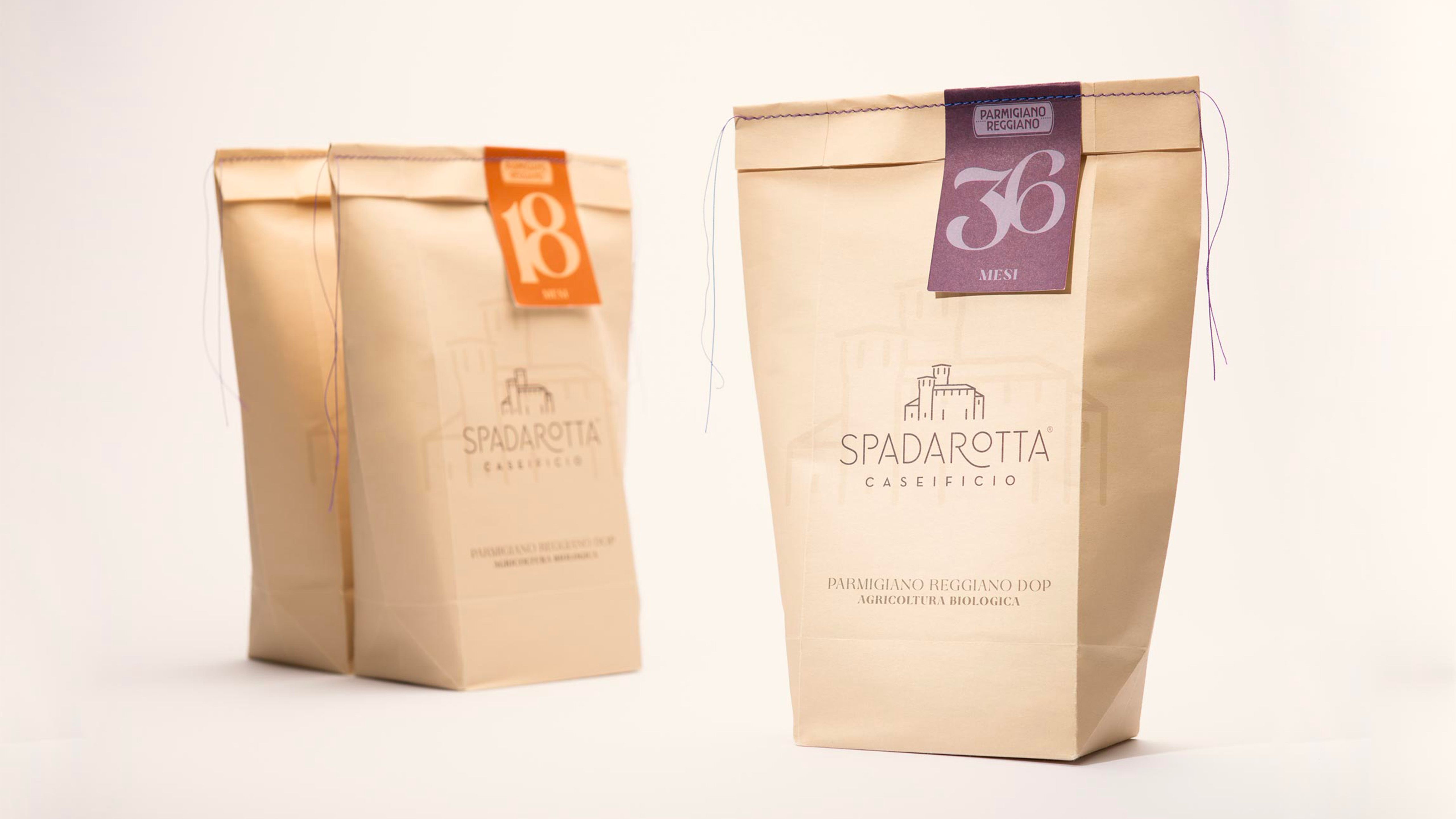 Two paper packs of Spadarotta Parmigiano Reggiano, aged 18 and 36 months, on a light background