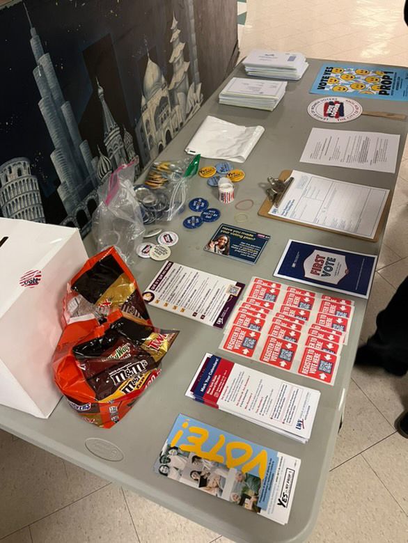 Students at a Vote of Teens registration table