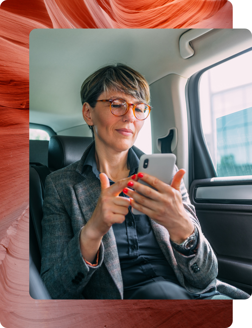 white woman in a car with a phone and red glasses