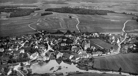 Historisches Luftbild von Auhausen: das Dorf mit der Klosterkirche zwischen Weiher und Feldern, dahinter der Kellerberg.