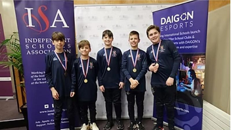 Five medal-winning pupils in front of ISA and DAIGON banners at the National Finals