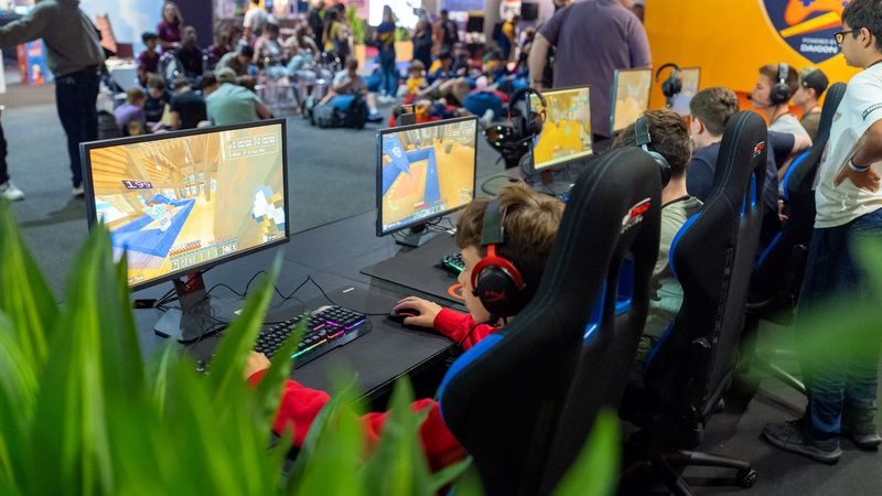 Students competing at gaming PCs in front of a crowd at a DAIGON championship final