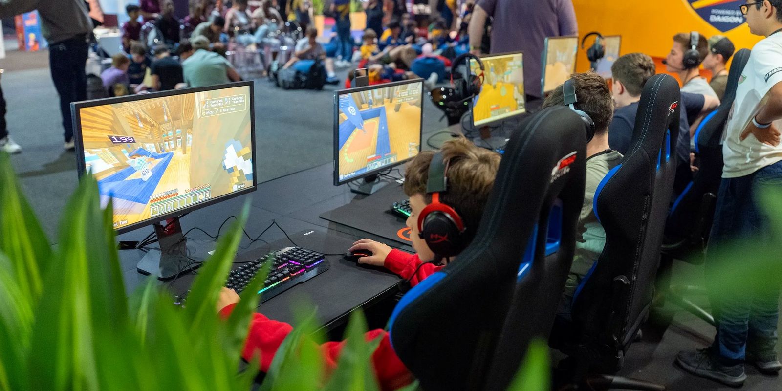 Students competing at gaming PCs in front of a crowd at a DAIGON championship final