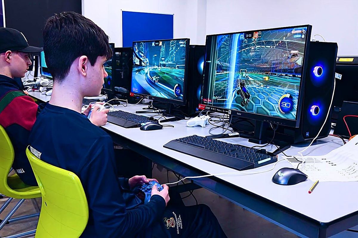 A pupil plays Rocket League with a controller at a gaming PC