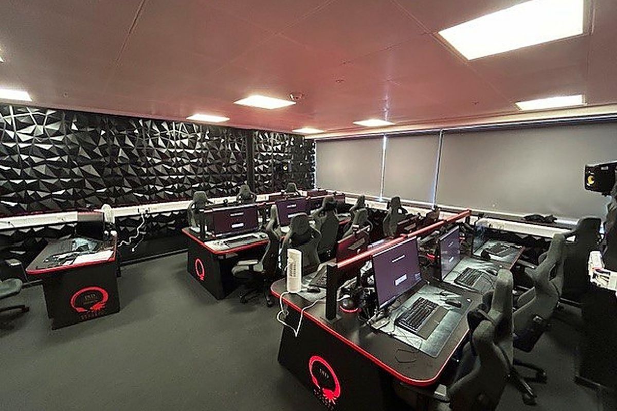 The esports suite at DLD College London, rows of gaming PCs with red-lit desks