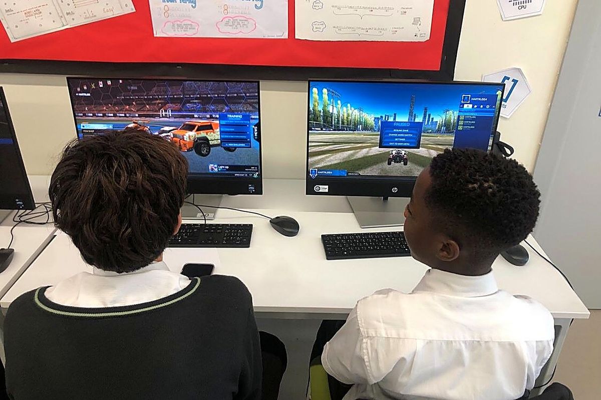 Two students playing Rocket League side by side in their school
