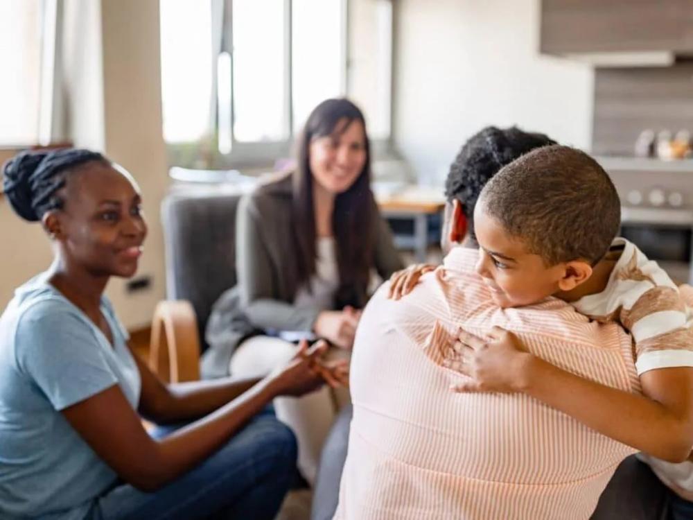 Family embracing during a therapy session at Select Psychology