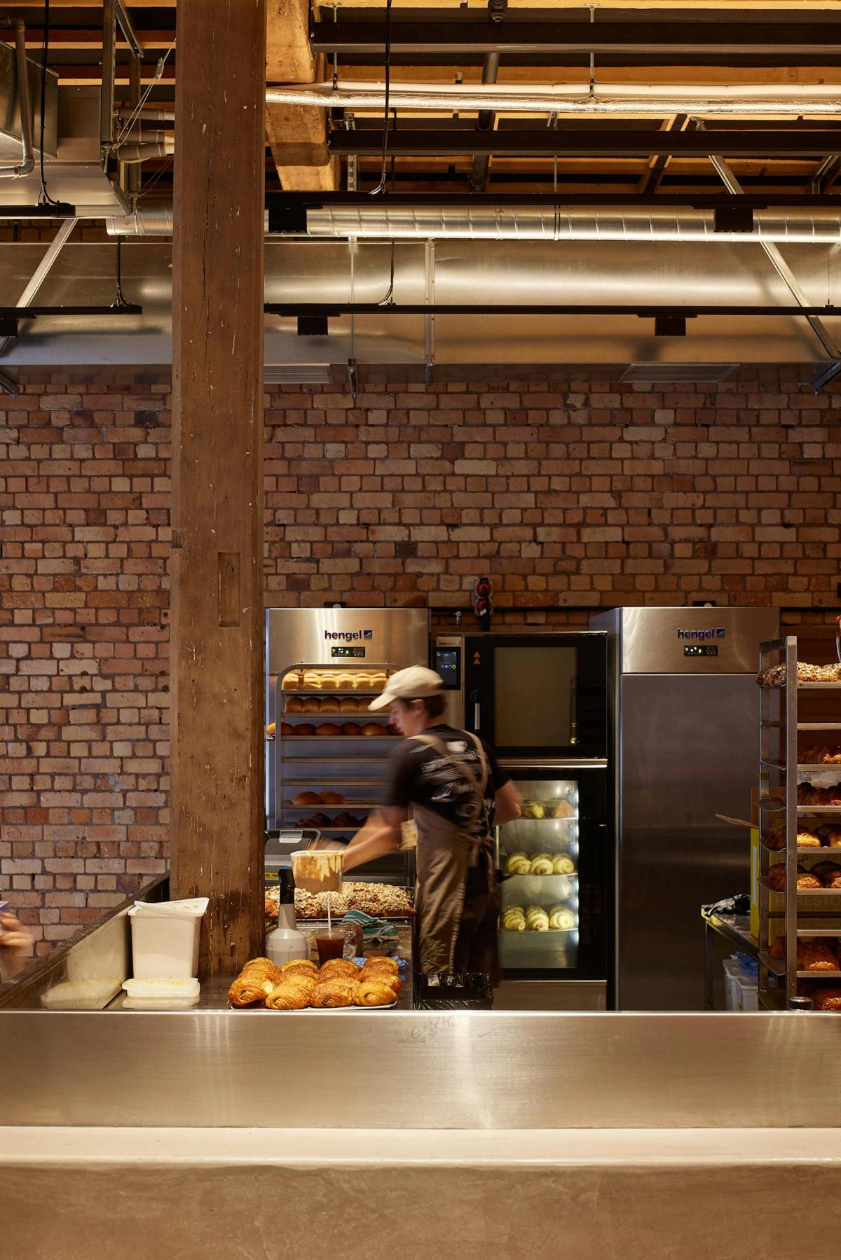Open-plan kitchen and jarrah leaners at Daily Bread Britomart in Auckland