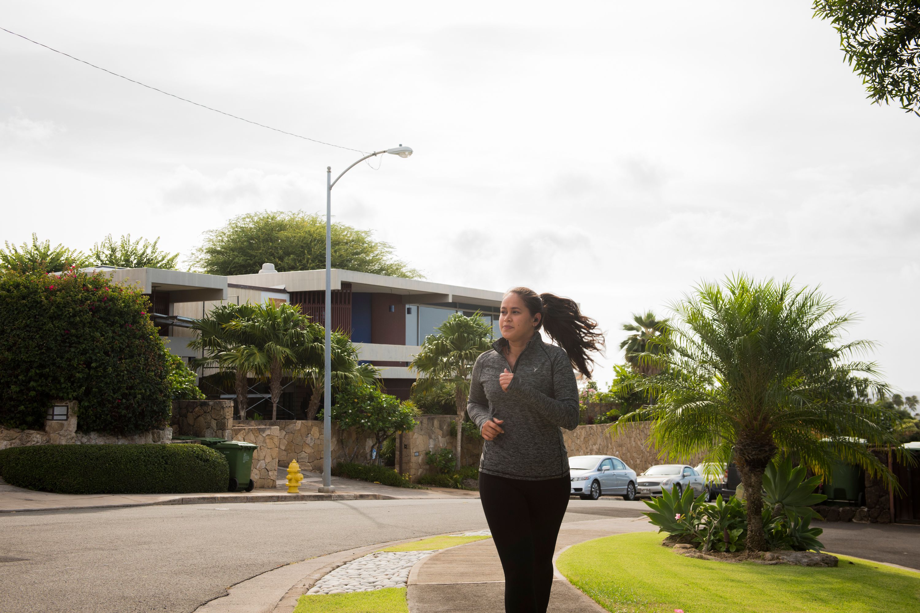 Woman jogging through a neighborhood with homes in the background
