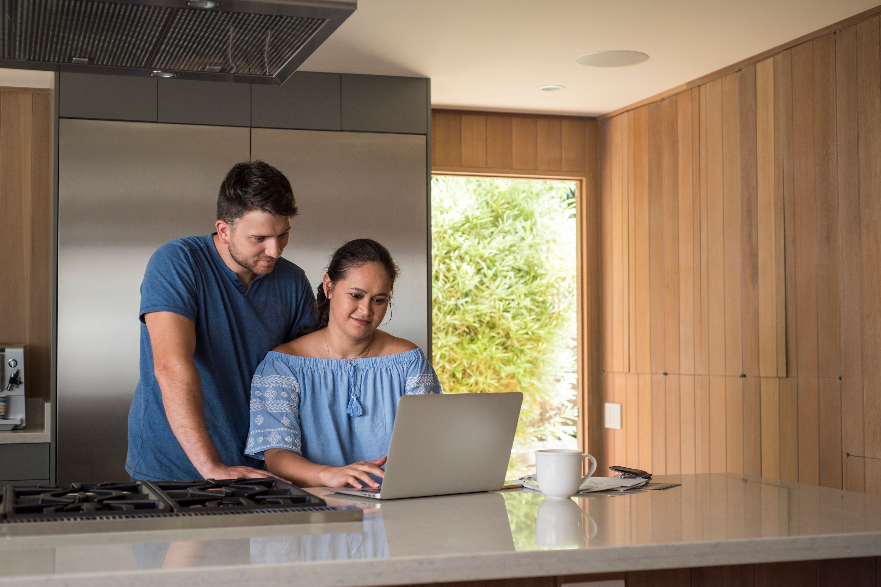 Couple in a kitchen looking at a laptop