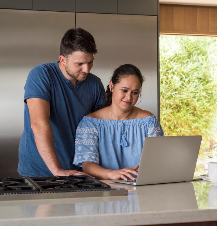 Couple in a kitchen looking at a laptop