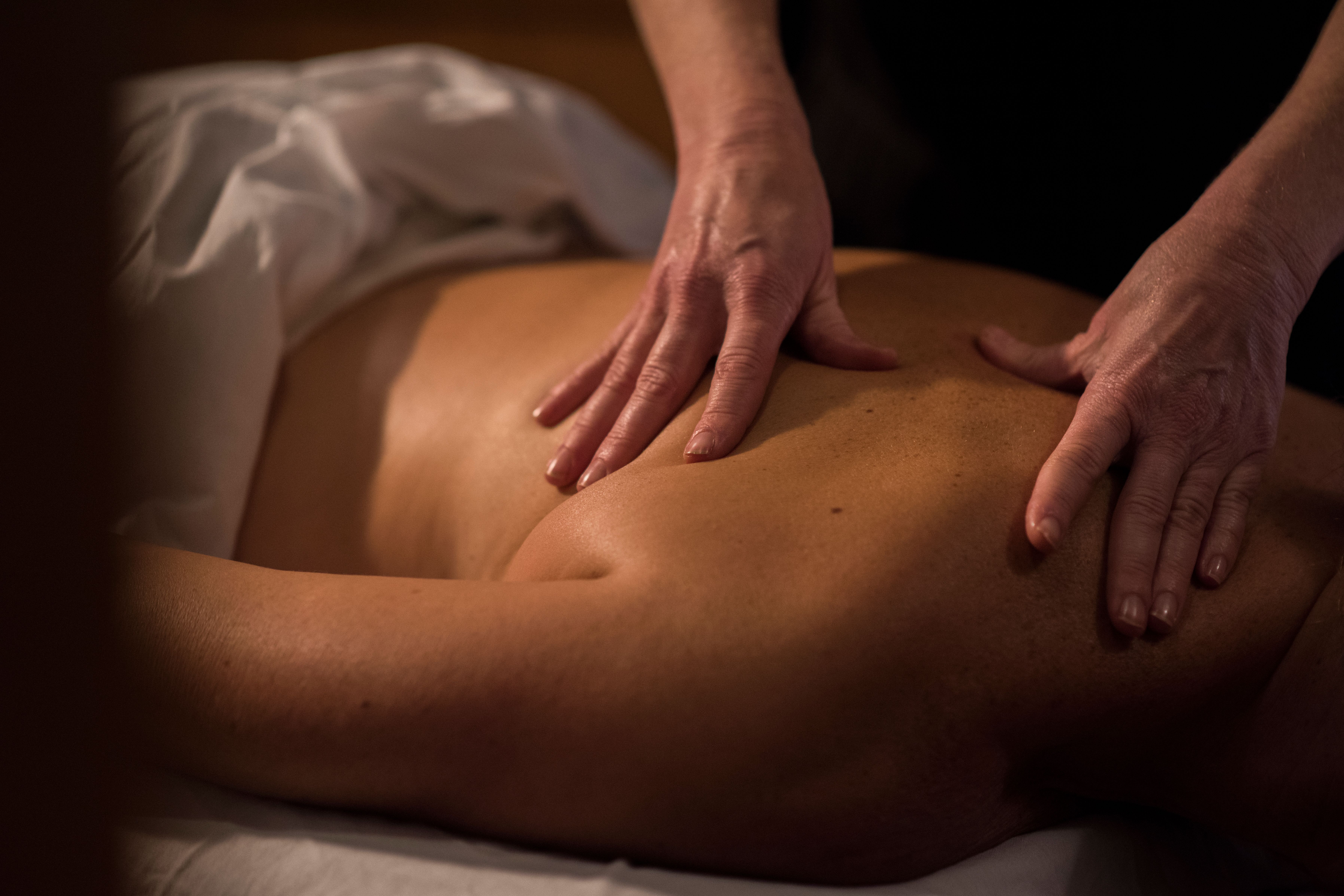 Video cover image shows hands massaging a spa client's back in treatment